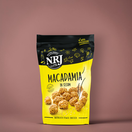 Macadamia Nüsse mit Sesam umhüllt von NRJ. In einem gelben wiederverschließbaren Beutel
